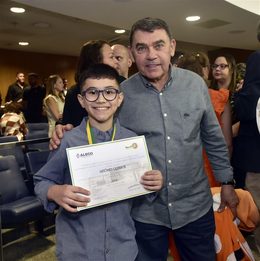 Aluno do OMNI recebendo certificado de mérito por alto desempenho em olimpíada de matemática