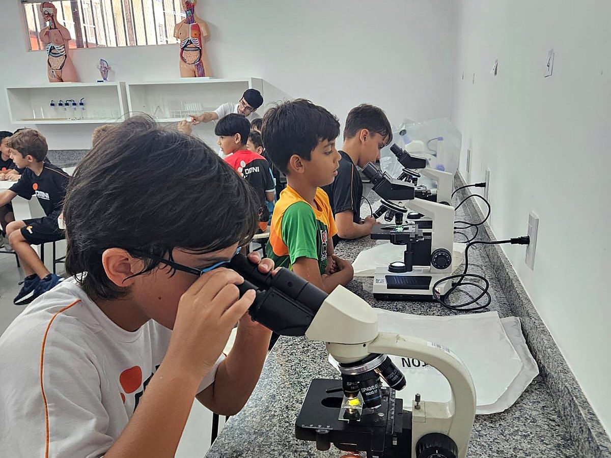 Alunos do OMNI usando microscópios no Laboratório de Ciências